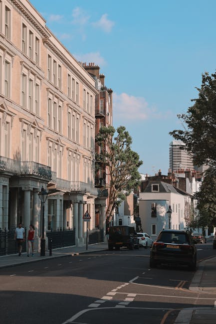 A view of a narrow urban street with red brick buildings on both sides, featuring multiple white-framed sash windows and street signs indicating Balderton Street and Providence Court in Earls Court. I